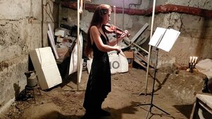 a woman plays violin in a bomb shelter